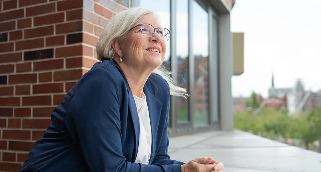 Portrait of Ulrike Mönkemöller in teal cardigan against concrete wall, conveying calm professionalism and approachability as a transformation guide.