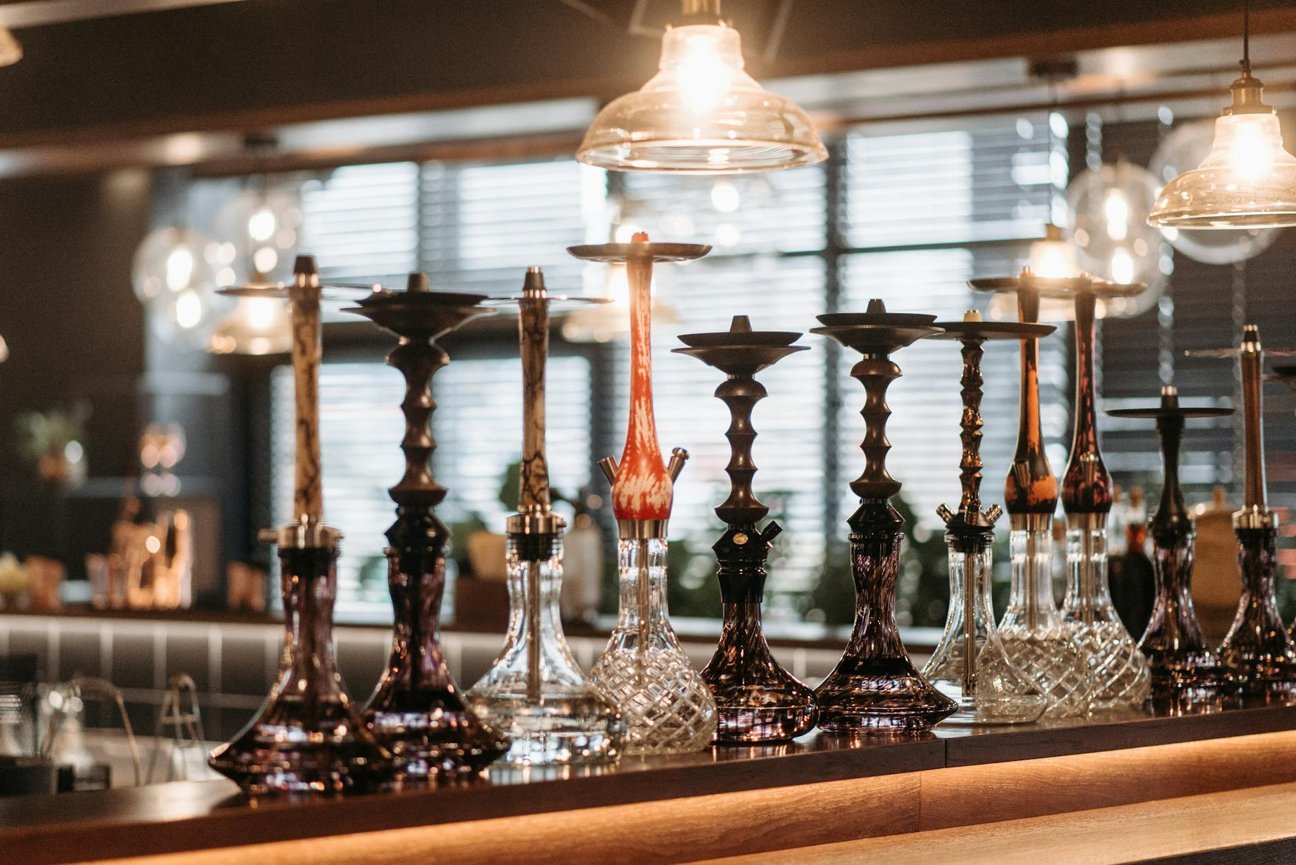 Eine Gruppe junger Erwachsener sitzt in einer gemütlichen Shisha-Lounge in der Schweiz, während Rauch aus der Wasserpfeife aufsteigt – ein Bild, das die Anziehungskraft, aber auch die versteckten Risiken des Shisha-Rauchens symbolisiert.